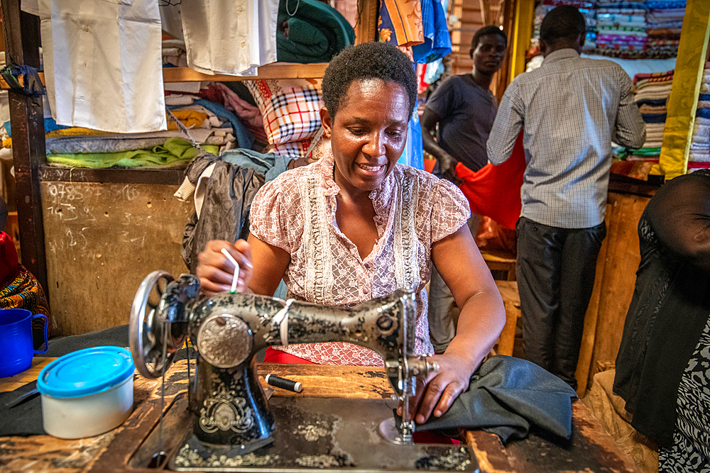 Seamstress working sewing machine, Kimironko Market, Kigali Rwanda