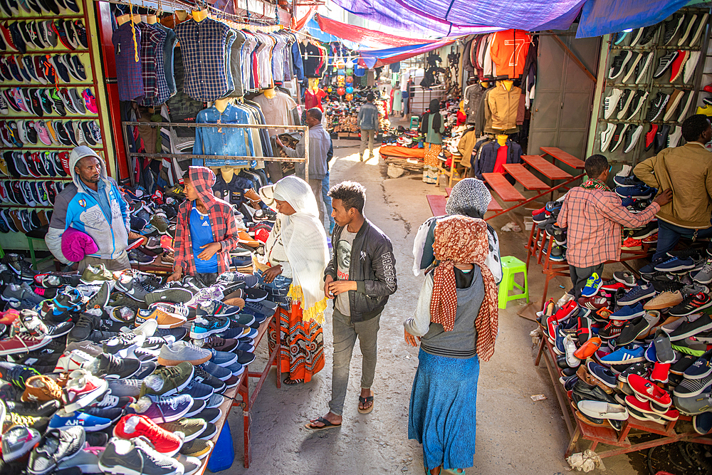 People stop and look at shoes for sale in a street market storefront, Debre Berhan, Ethiopia