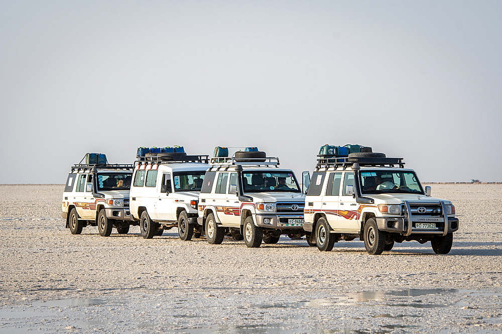 Land Cruisers drive through the salt flats in the Danakil Depression, Ethiopia