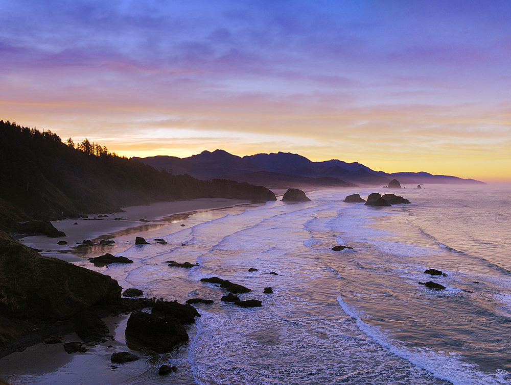 View of Crescent Beach, Cannon Beach, Haystack Rock and coast to Hug Point from Ecola State Park at sunrise; Oregon.