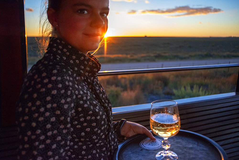 A waitress serving South African wine in The Rovos Rail luxury train travelling between Cape Town and Pretoria in South Africa Pride of Africa beautifully rebuilt Classic train that form part of the luxurious and privately owned Rovos Rail fleet