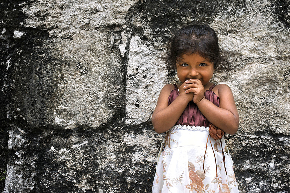 Local Girl in Tikal Pyramid ruins (UNESCO site), Guatemala. Great Jaguar Temple (Temple I) Pre-Columbian Maya Site at Tikal, El Peten National Park, Guatemala, a UNESCO World Heritage Site