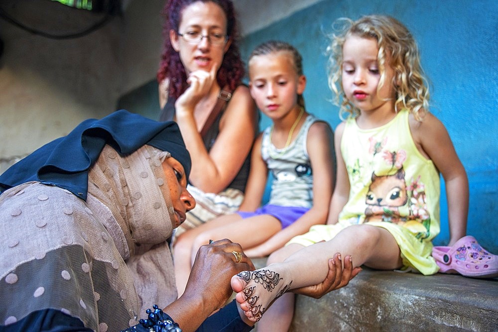 Swahili Woman paint with Henna And Indigo some european tourists in Lamu, Lamu Archipelago, Kenya