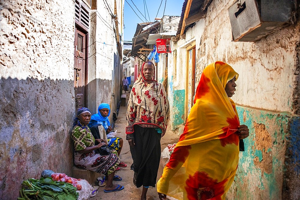 Swahili women with colorful veils in the strees of the city town of Lamu in Kenya