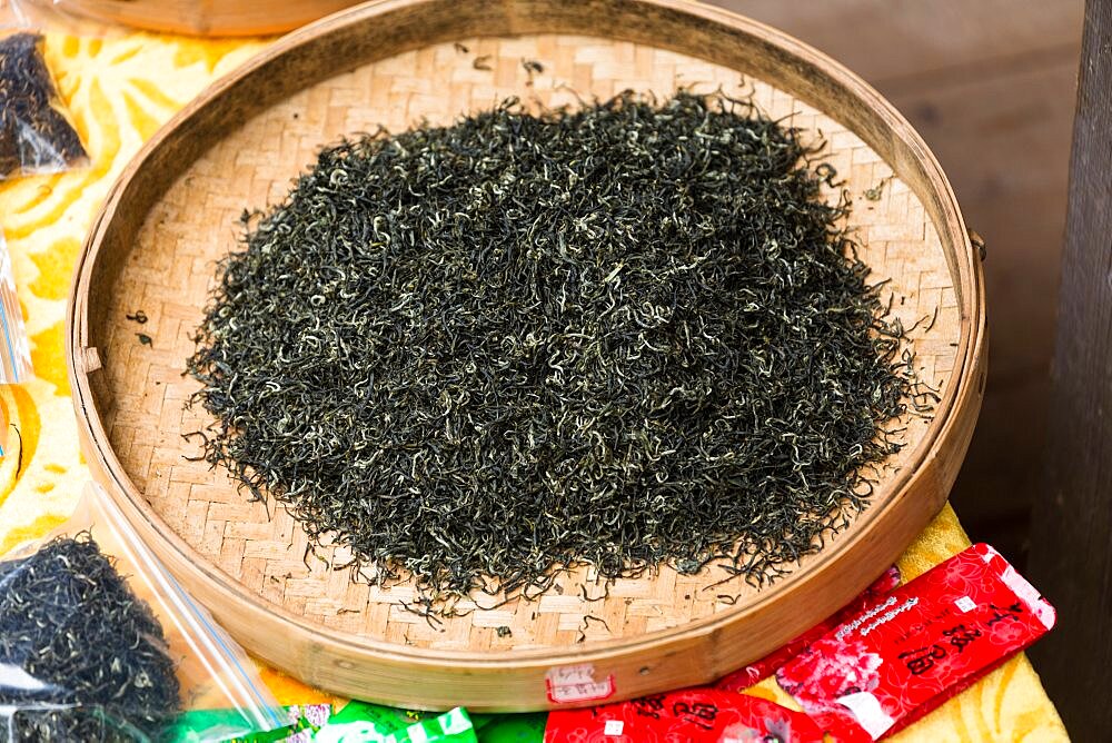 Dried tea in a bamboo tray for sale in the Longshen Longi rice terraces. China.