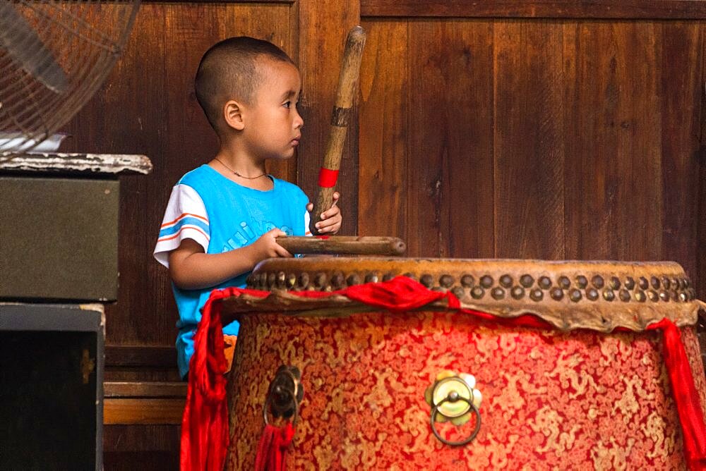 A young Yao boy beats a traditional drum before a cultural performance in Huangluo, China.