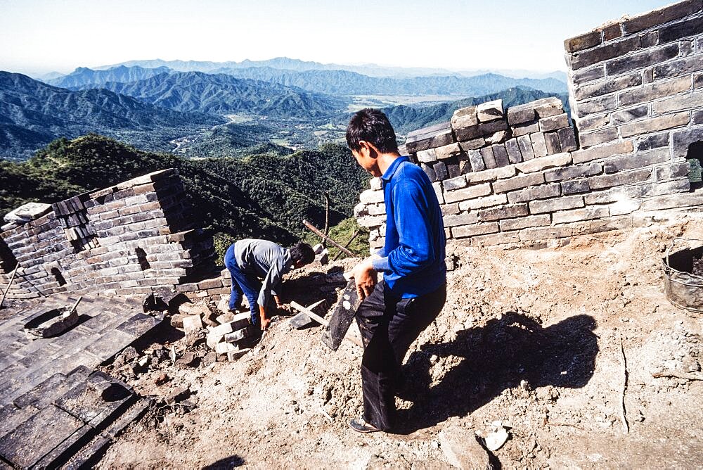 Two Chinese men working on the restoration of the Great Wall at Mutianyu, China.