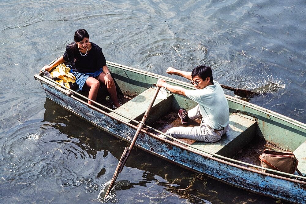 A young Chinese couple in a rowboat on Kunming Lake. Summer Palace, Beijing, China.