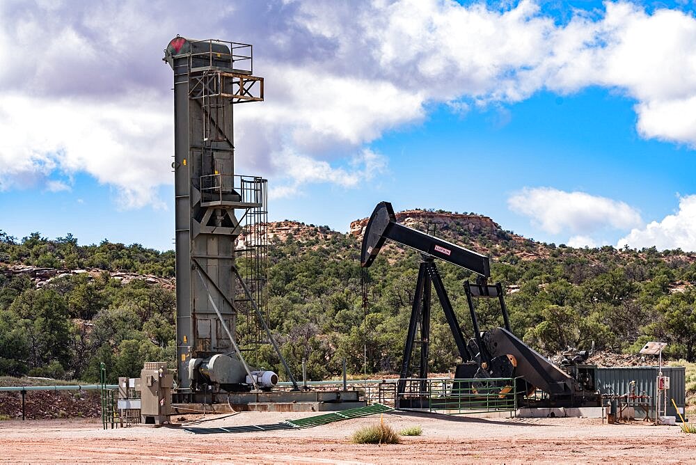 A long stroke belt pump and a traditional pump jack on adjacent oil wells in the canyon country of Utah.