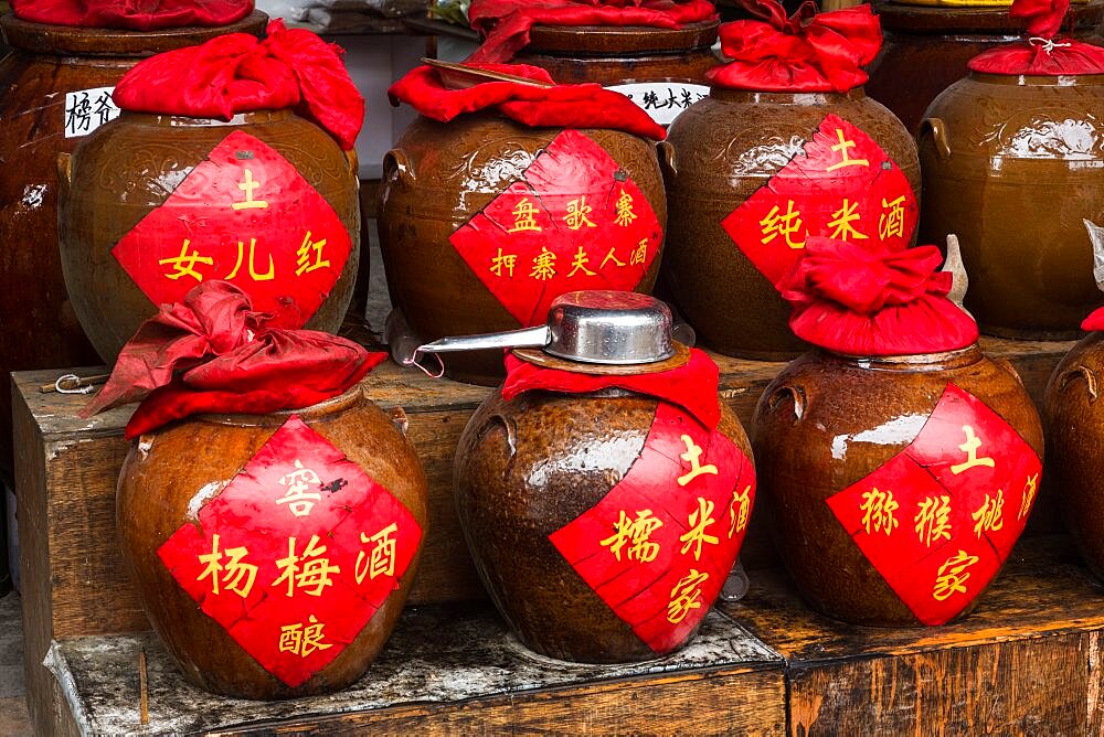 Ceramic jars of rice wine for sale on the street in the ancient town of Furong in Hunan Province, China.