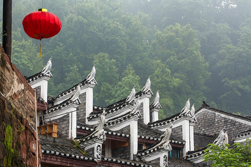 Upturned sculptures representing phoenix birds on the roof of a traditional building, Fenghuang, China.