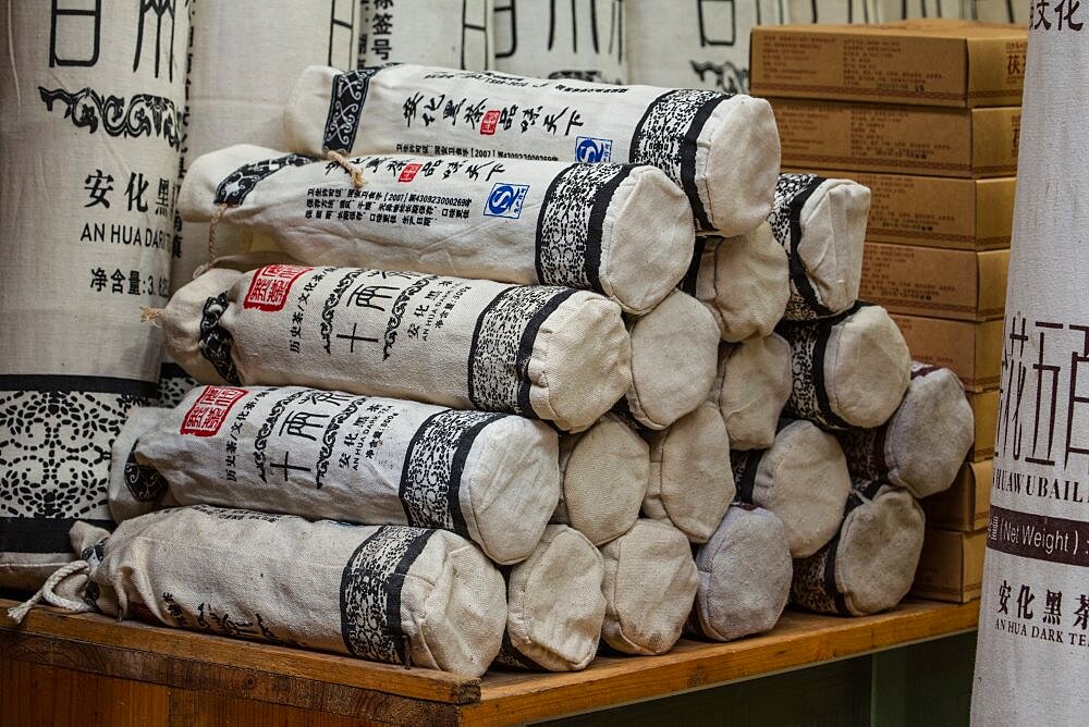 A stack of bags of An Hua Dark tea for sale in a tea shop in Fenghuang, China.