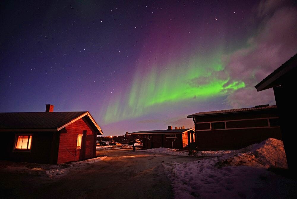 Aurora Borealis (Northern Lights) over VisitInari wood cabins in Lake Inari, Lapland, Finland