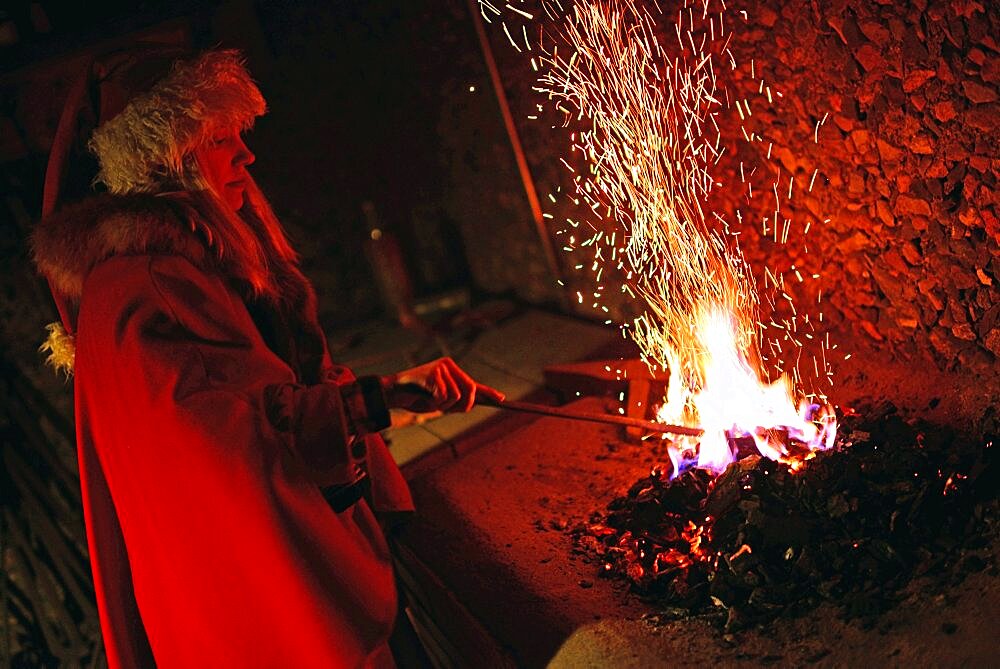 Young elf throws magical powders in the fire. Kakslauttanen Arctic Resort in Saariselka, Finland