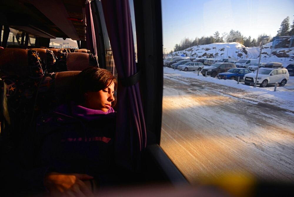 Young woman travelling by bus to Pyha ski resort, Lapland, Finland