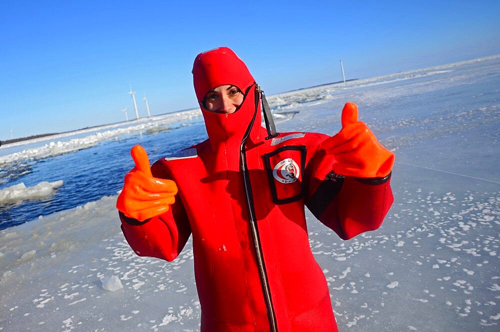 Young woman swimming in the frozen sea during Sampo Icebreaker cruise, an authentic Finnish icebreaker turned into touristic attraction in Kemi, Lapland