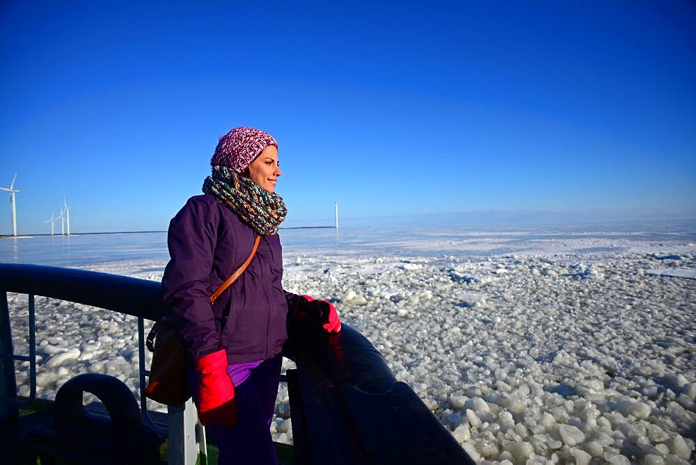 Young woman enjoying Sampo Icebreaker cruise, an authentic Finnish icebreaker turned into touristic attraction in Kemi, Lapland