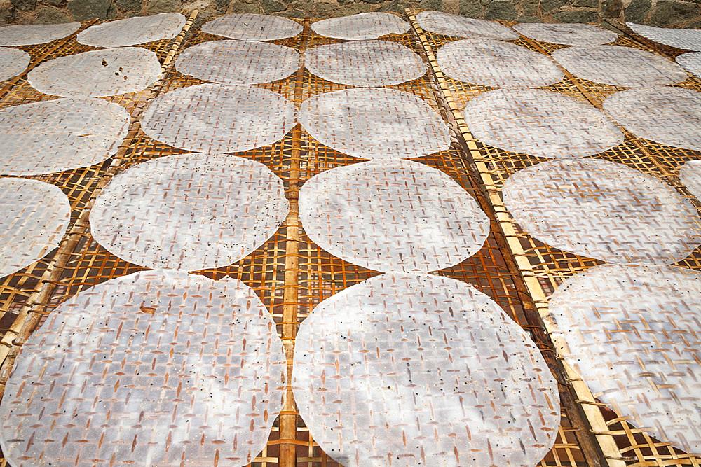 Rice paper circles drying outdoors on a bamboo lattice drying frame, Cuu Long, Cai Be, Mekong Delta, Vietnam