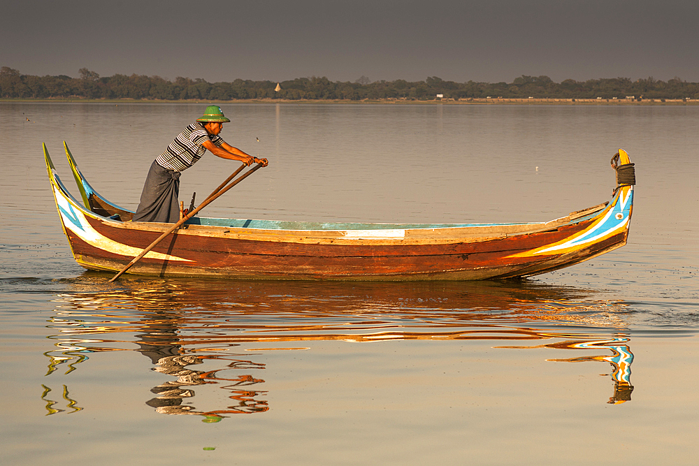 Fisherman rowing his boat on Taungthaman Lake, Amarapura, Mandalay, Myanmar, (Burma)