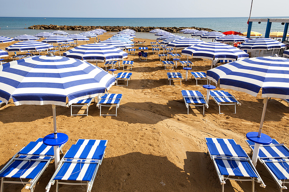 Sun umbrellas and sun beds on a beach, Marina Di Ragusa, Sicily, Italy