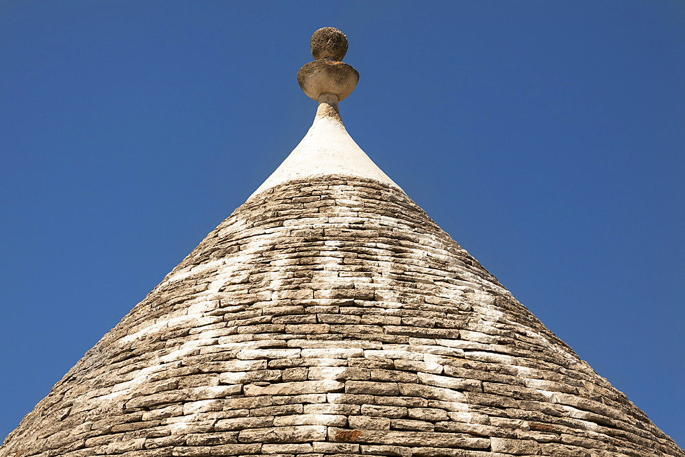 Conical dry stone roof of trulli house, with painted sun symbol, Alberobello, Bari province, Puglia region, Italy