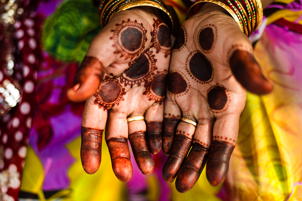 A woman showing her henna tattoed hands