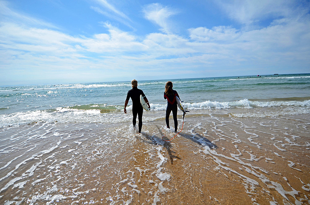 Surfers on Cote des Basques beach at sunset, Biarritz