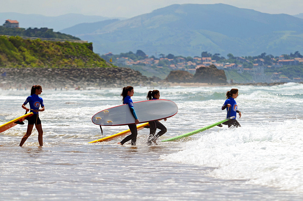 Surfers on Cote des Basques beach at sunset, Biarritz