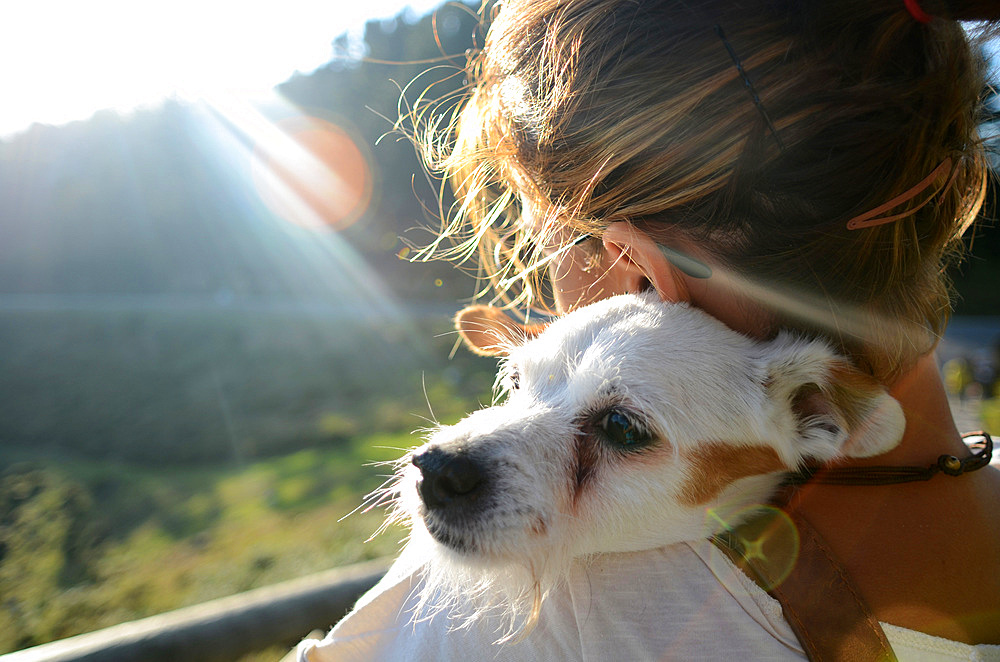 Attractive young woman poses with her small white dog