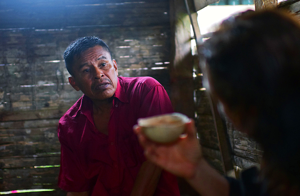 Karine drinks cacao while talking with Catato, after preparing natural cacao drink at Bribri tribe house, A day with the Bribri, indigenous people in Lim?n Province of Costa Rica,