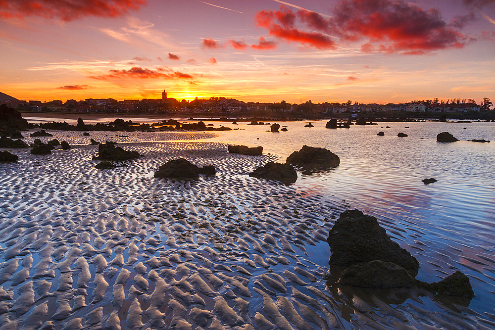 Rocky beach and village at dusk. Trengandin beach. Noja, Cantabria. Spain, Europe.