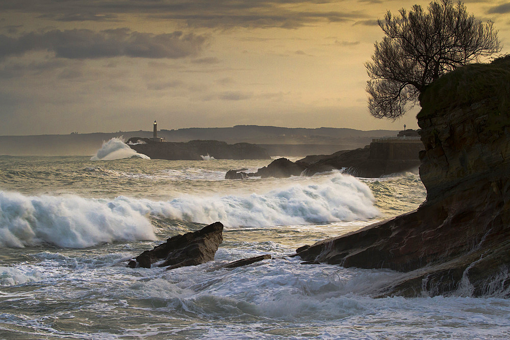 Mouro island and lighthouse in a storm. 
Santander. Cantabria, Spain.