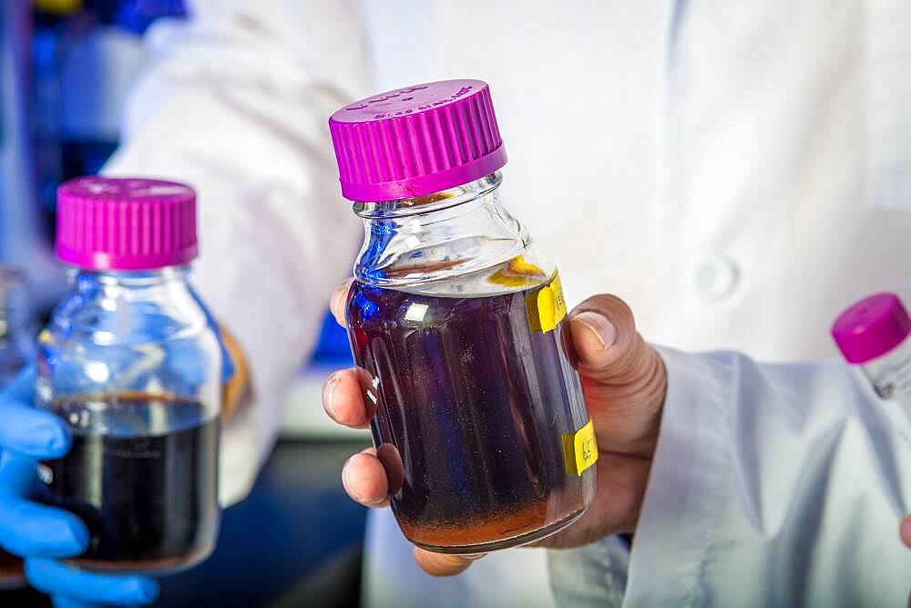 Scientist in laboratory with purple liquid