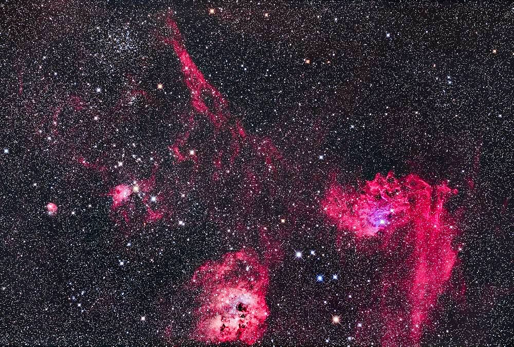 This is the rich region in the centre of the constellation of Auriga with the Flaming Star Nebula, IC 405 at right, and the roundish IC 410 at bottom with the cluster NGC 1893. At top left is the star cluster Messier 38, with small NGC 1907 below it. The small nebula at left is IC 417 around the loose cluster Stock 8. The large elongated nebula at top is Sharpless 2-230. The colourful asterism of stars between IC 405 and IC 410 is the Leaping Minnow or Little Fish, aka Mel 31.