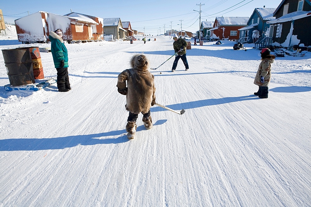 Villagers play ice hockey in the streets of Gojahaven, an Inuit settlement in the far north of Canada.