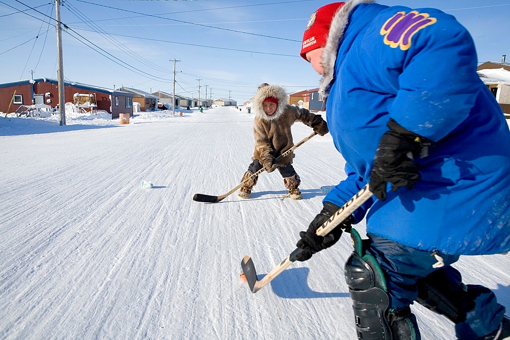 Villagers play ice hockey in the streets of Gojahaven, an Inuit settlement in the far north of Canada.