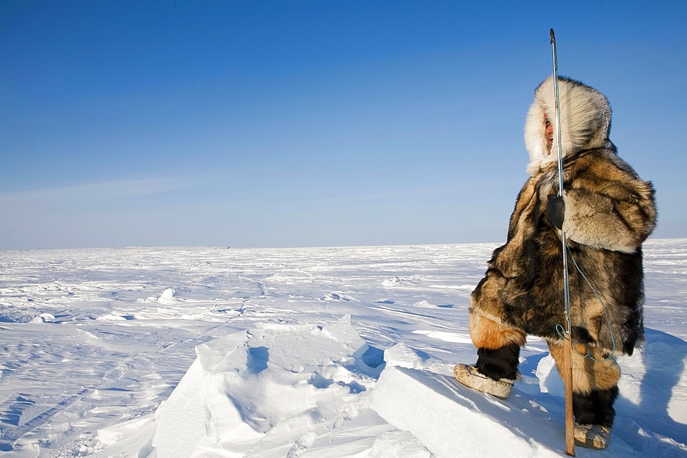 Man looks for animals to hunt in Gojahaven, an Inuit settlement in the far north of Canada.