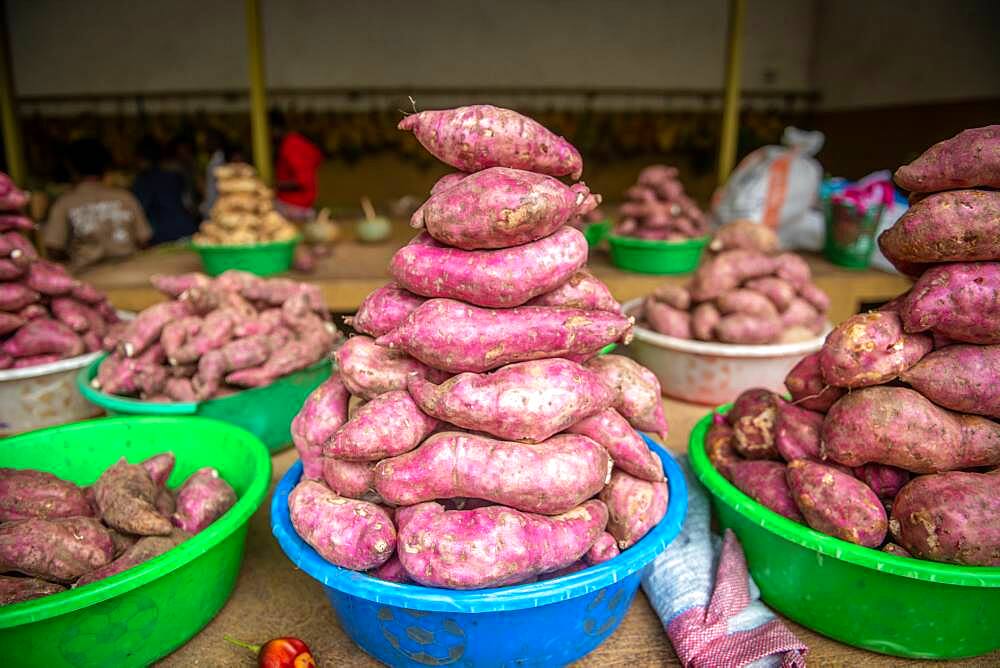 Sweet potatoes stacked in plastic bins at outdoor market, Rwanda Farmers Market, in Rwanda