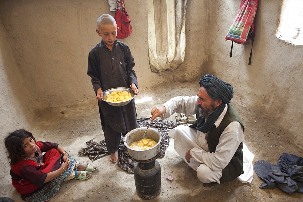 Afghan refugees preparing a potatoe meal, Afghanistan