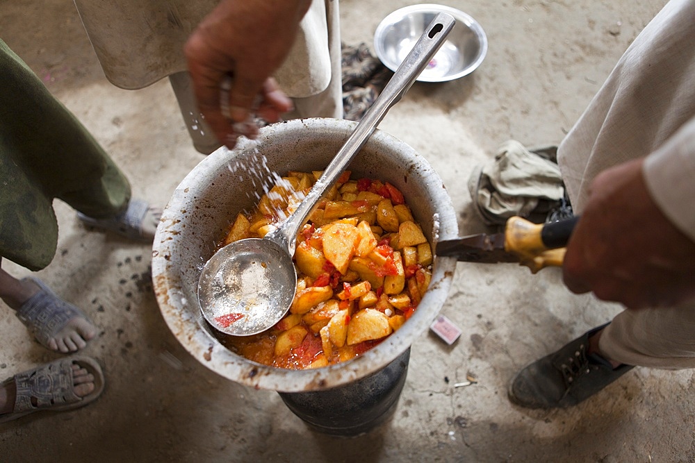 Afghan refugees preparing a potatoe meal, Afghanistan