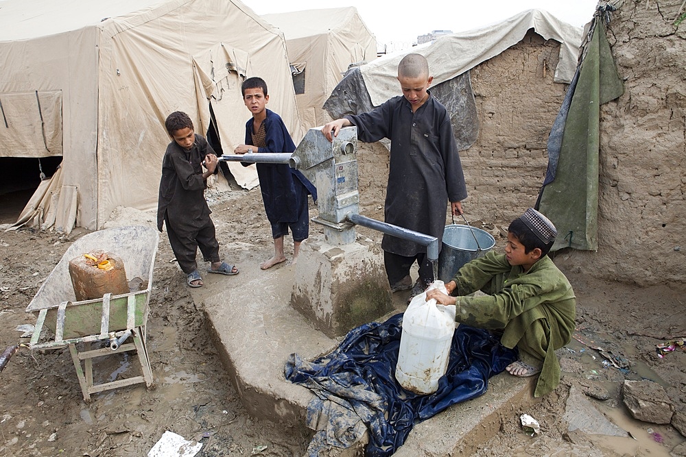 Afghan refugee child fetching water from the well