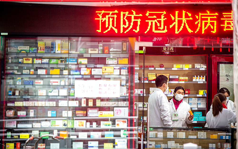 Shanghai, China, 27th Jan 2020, Outside of pharmacy with technicians talking inside wearing masks