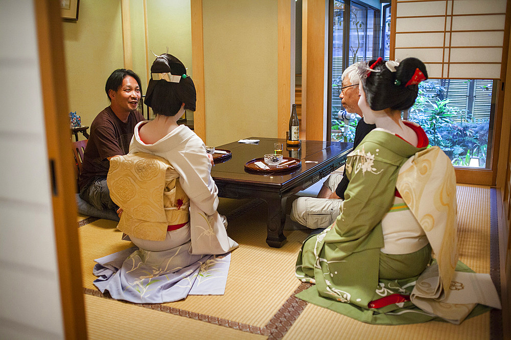 Fukuyu,geisha and Fukukimi,'maiko' (geisha apprentice) workimg in Miyaki tea house (o-chaia).Geisha's distric of Miyagawacho.Kyoto. Kansai, Japan.