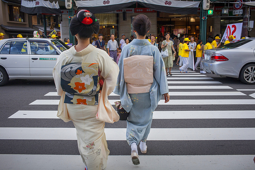 Geisha and 'maiko' (geisha apprentice) in Shijo dori street.geisha's distric of Gion, ,Kyoto. Kansai, Japan.