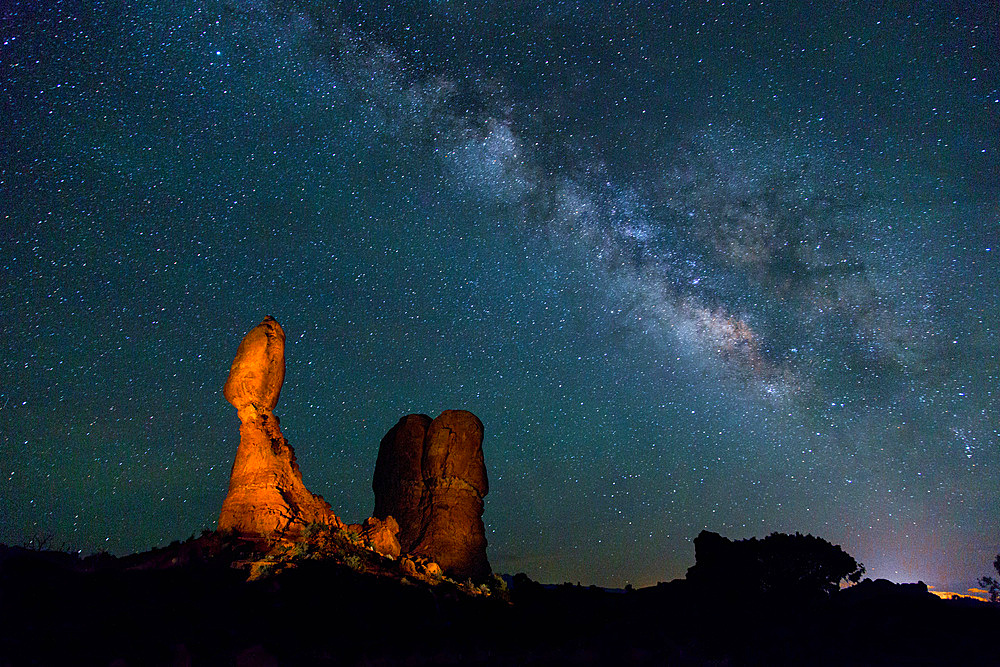 The Milky Way over Balanced Rock in Arches National Park, Moab, Utah, USA. A small spotlight was used to light paint the rock formation.