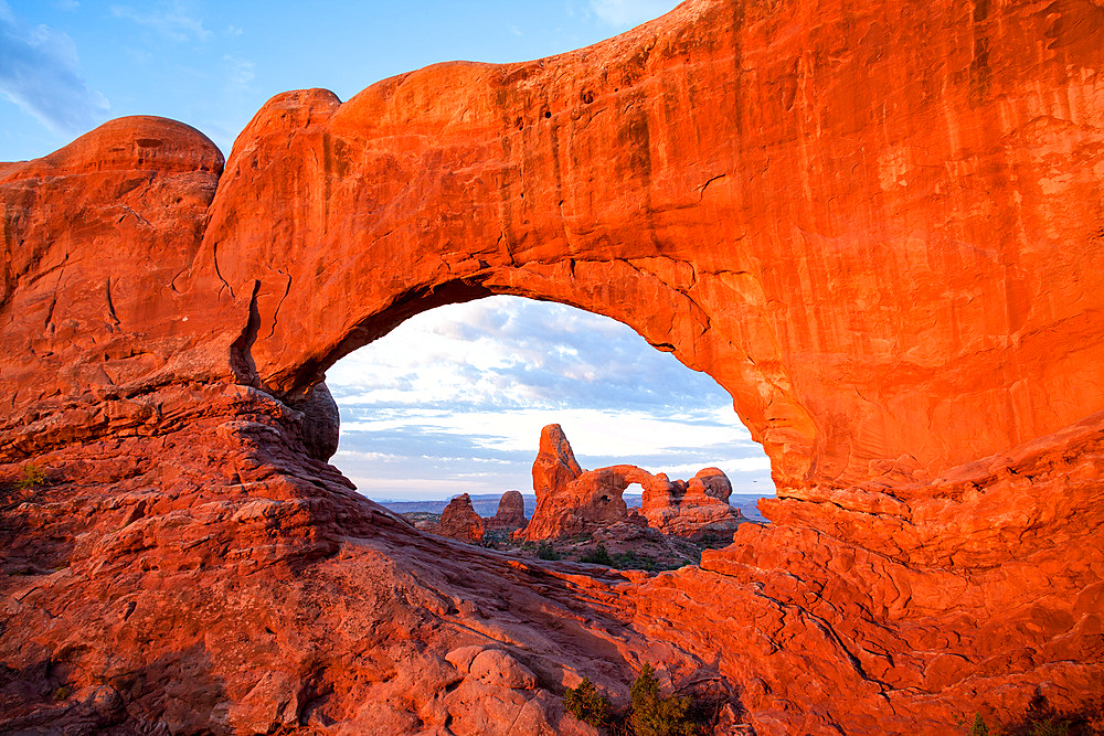 Turret Arch framed by the North Window at sunrise. Arches National Park, Moab, Utah.