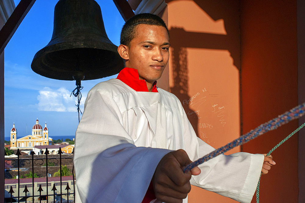 Altar boy ringing the bells in the Iglesia la Merced of Granada in Nicaragua Central America. Back cathedral of Granada Nicaragua