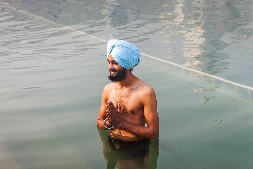 pilgrim bathing in the sacred pool Amrit Sarovar, Golden temple, Amritsar, Punjab, India