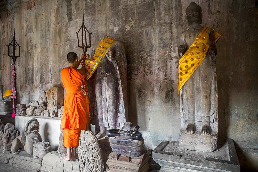 Monk embellishing religious sculptures, in Angkor Wat, Siem Reap, Cambodia