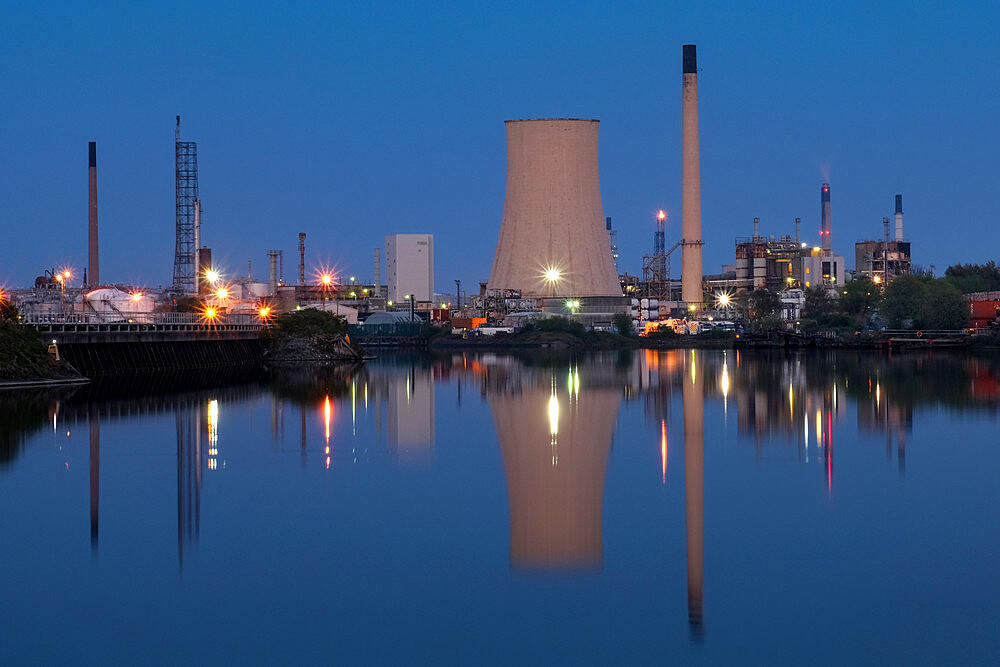 Stanlow Oil Refinery reflected in the Manchester Ship Canal at night, near Ellesmere Port, Cheshire, England, United Kingdom, Europe